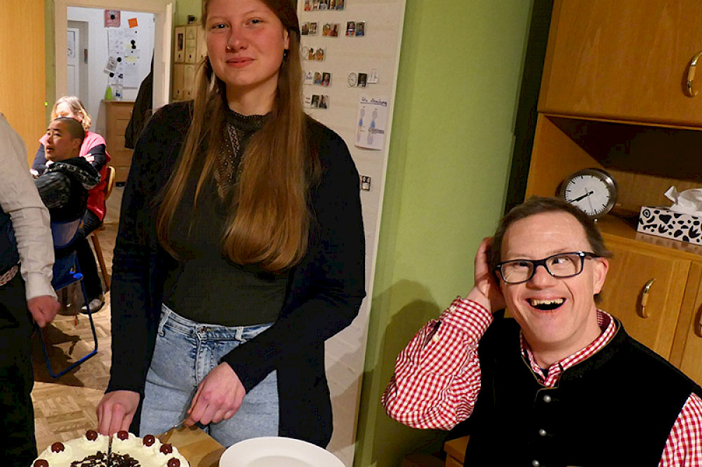Image shows people enjoying some cake together.